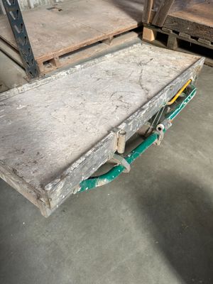 une table en bois avec une poignée verte dans un entrepôt