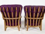pair of purple upholstered chairs with wooden arms and legs