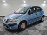 la photo d'une petite voiture bleue garée sur un sol en damier
