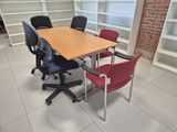 a table and chairs in a room with bookshelves