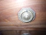 a wooden dresser with a metal knob on it