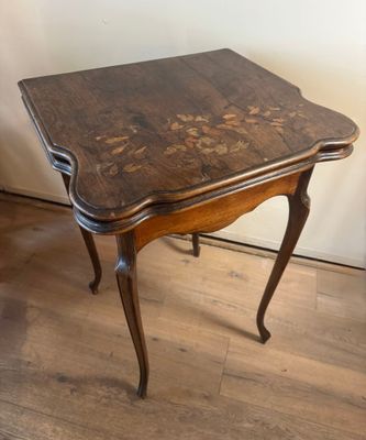 a small table with a wooden top on a hard wood floor