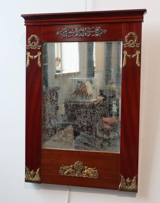 un miroir accroché au mur dans lequel se reflète une personne