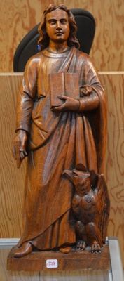 une statue en bois représentant un homme avec un chat posé sur une table