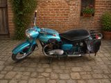 une moto bleue garée devant un immeuble en briques
