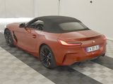 an orange car parked in a garage with a checkered floor