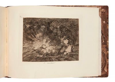 un livre ouvert sur lequel figure le dessin d'un homme et d'une femme assis autour d'un feu de camp