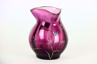un vase en verre violet orné d'un papillon