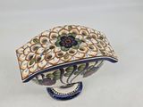 a decorative bowl with a flower on it on a stand