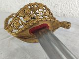 a gold colored object with a red handle on a table