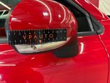 a close up of a red car with a measuring tape on the side mirror