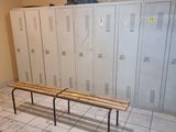 un banc au milieu d'une pièce, avec des casiers en arrière-plan