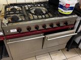 a stove that is sitting in a kitchen with a bucket of paint on it