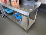 une table en acier inoxydable sur laquelle est posé un sac bleu