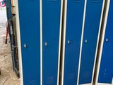 Trois casiers métalliques bleus sont empilés dans un garage