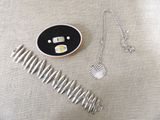 un collier en argent et un peigne en argent posés sur une table