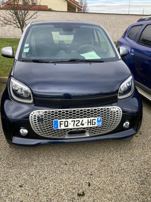 La Smart est garée sur un parking, à côté d'une voiture bleue