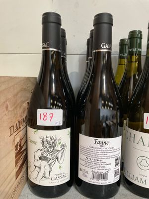plusieurs bouteilles de vin posées sur un comptoir, à côté d'une caisse en bois
