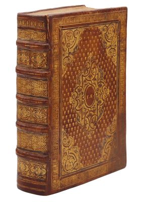 un vieux livre relié en cuir, orné de motifs élaborés sur la couverture et les tranches