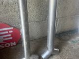 two metal poles on the ground next to a brick wall