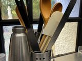 many kitchen utensils in a cup on the counter