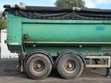 a green dump truck with a tarp on the back of it
