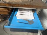a blue drawer with papers on it in a room