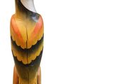 un oiseau en bois posé sur une surface blanche