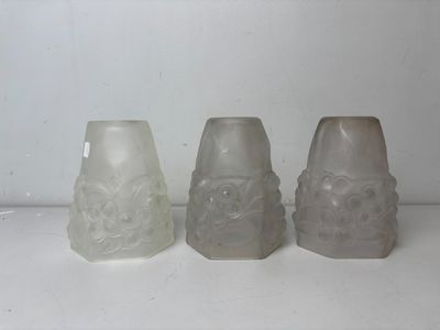 three frosted glass vases sitting on top of a white counter