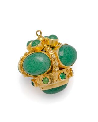 un gros plan d'une bague ornée de pierres vertes sur un fond blanc