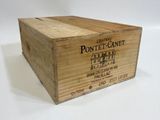 une boîte en bois portant une étiquette, posée sur une surface blanche