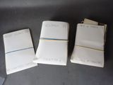 three notebooks with writing on them sitting on top of a table