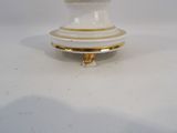 a white and gold vase on a white table