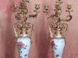 two vases sitting on a table with a pink wall behind them
