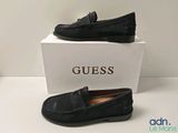 Des mocassins en cuir noir avec des pompons sur la semelle, je suppose