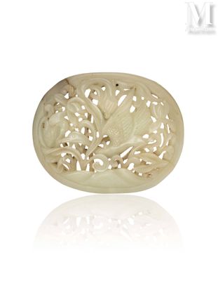 une plaque ovale en jade blanc sculpté, représentant des fleurs et des feuilles sur fond blanc