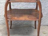 une petite table en bois sur laquelle se trouvent deux étagères