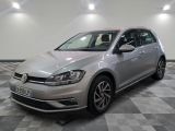a silver volkswagen golf is parked in a room with checkered floor