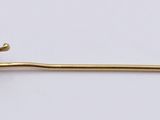 yellow gold plated pin with a flower on it on a white surface