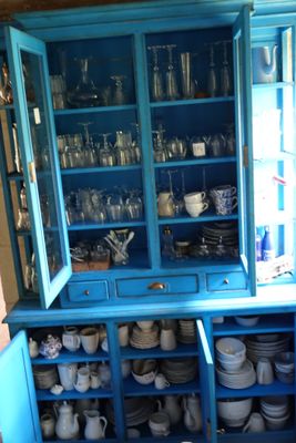 un vaisselier bleu sur lequel sont disposées de nombreuses assiettes