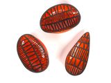 trois morceaux de verre rouge et noir posés sur une surface blanche