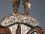 sculpture of a man standing on top of a building with a bird on top