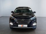 the front view of a black suv parked in a showroom