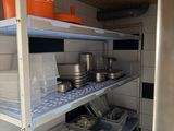 shelves with pots and pans on them in a small kitchen