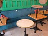 several tables and chairs in a room with a green wall