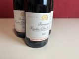 two bottles of wine sitting on top of a table next to each other