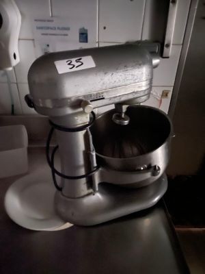a silver mixer sitting on a counter in a kitchen