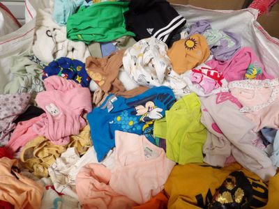 un gros tas de vêtements dans un sac posé par terre