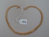 un gros plan sur un collier en or avec une étiquette de prix