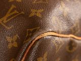 close up of a brown louis vuitton bag with a brown leather handle